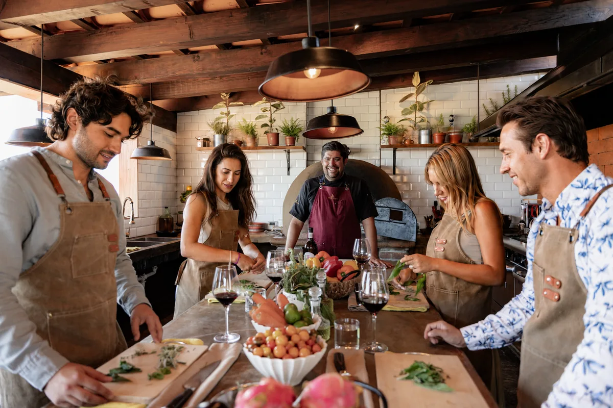 A cooking class in progress around the counter of the estate kitchen