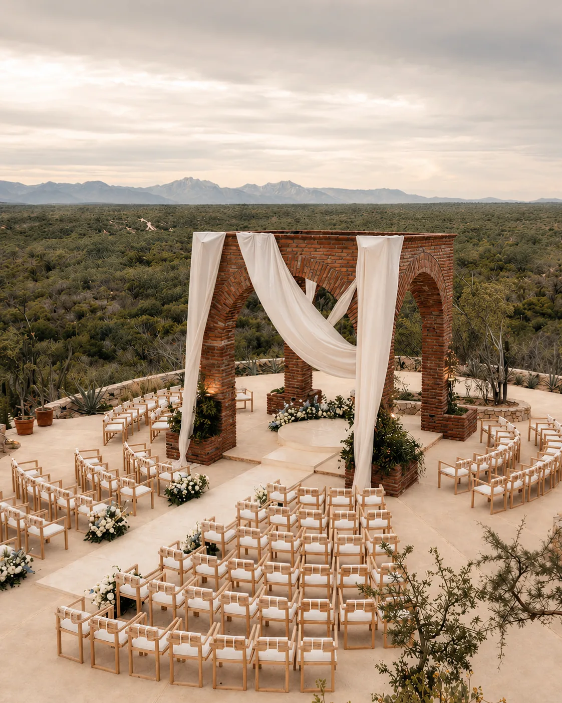 The brick arch draped in white linen with chairs set before it on the open terrace