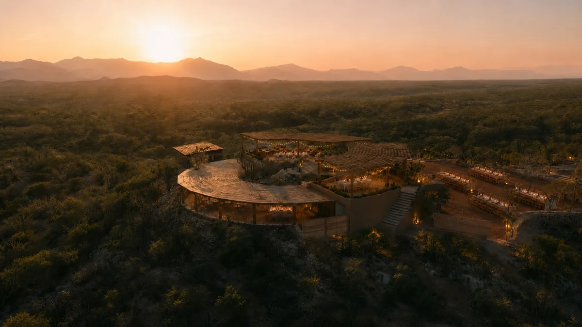 The estate on its hilltop with the sun setting behind the Sierra de la Laguna