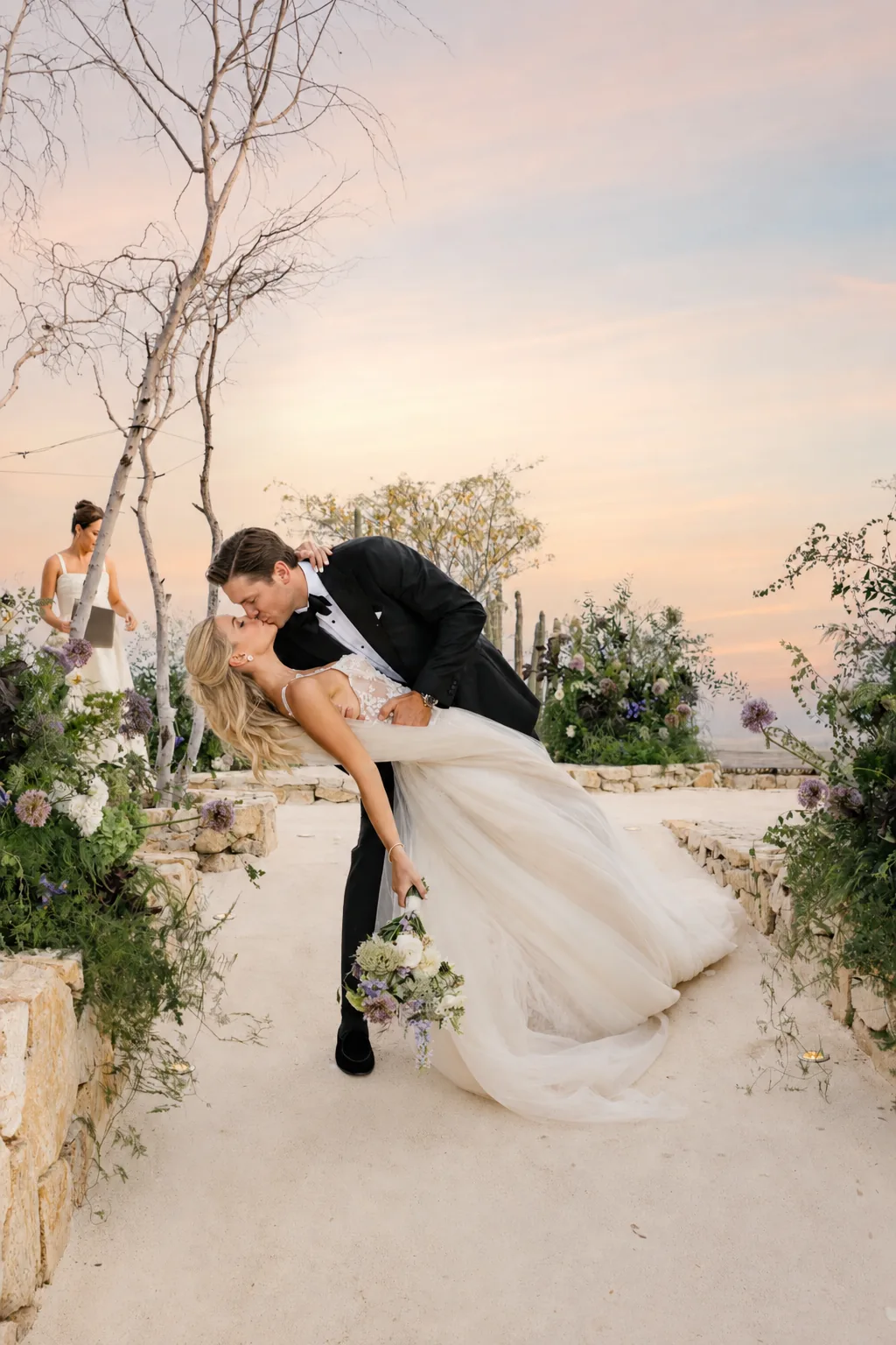 A couple on the estate terrace with the desert and evening sky behind