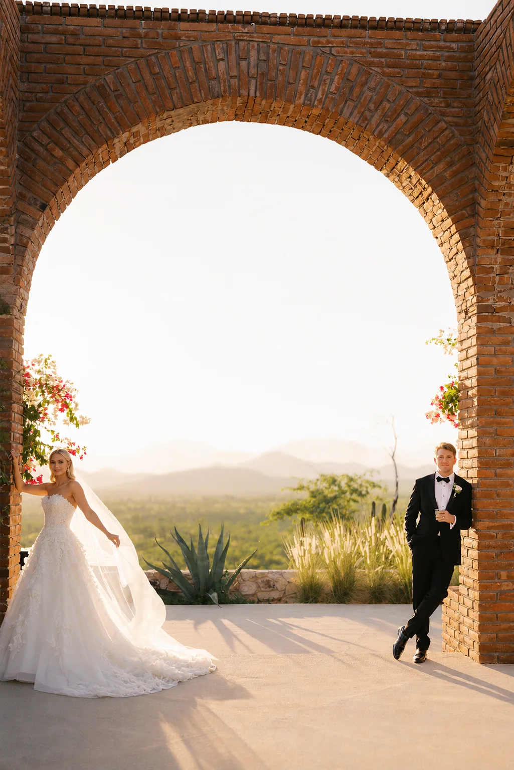 Bride walking through the brick arch with the desert behind her