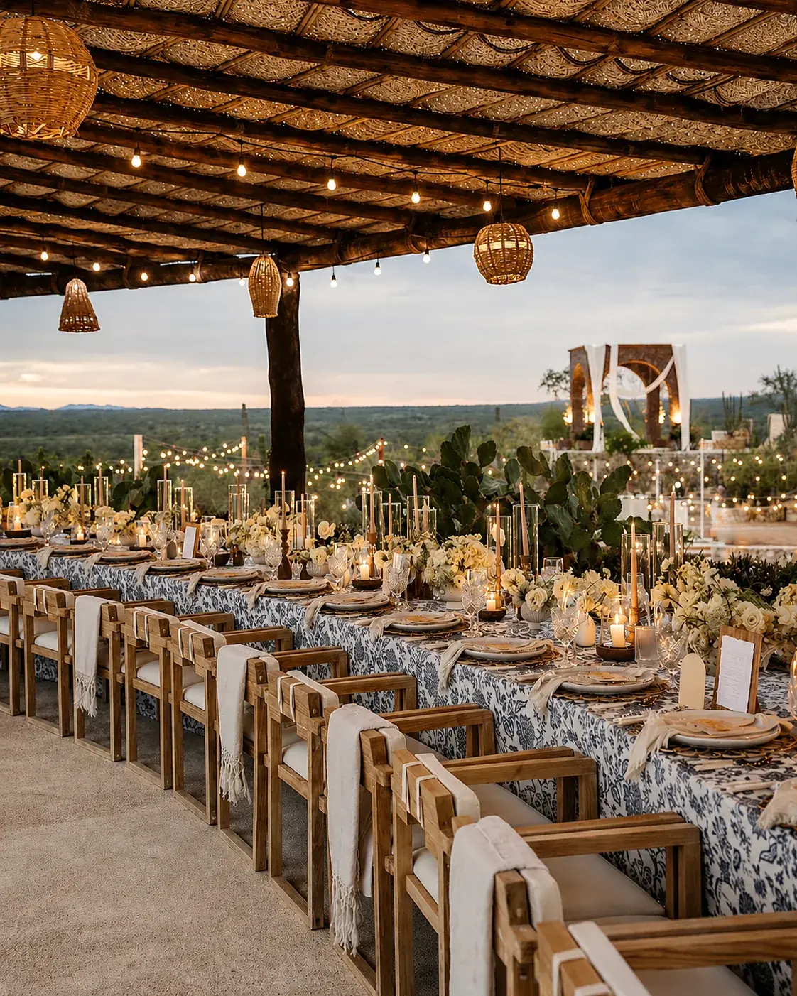 Long banquet tables under the palapa with candles and the mountains beyond