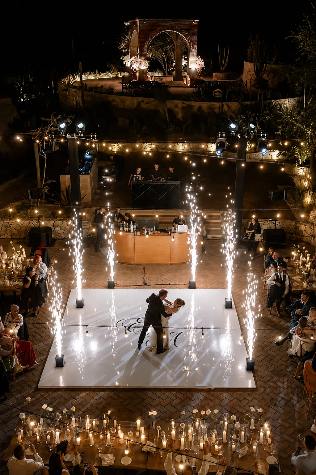 First dance on the white dance floor framed by cold sparks and candlelight
